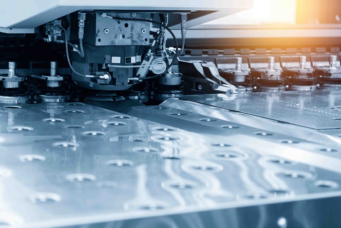 Close-up of the CNC punching machine in the light blue scene.High technology metal forming process.
